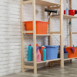 Cleaning Supplies Arranged on Wooden Shelves