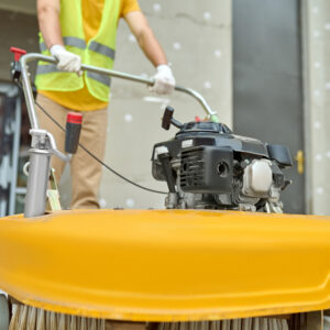 Workman applying a road sweeper on the construction site